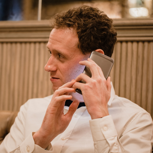 Mann hält Smartphone mit angeschaltetem Screenreader ans Ohr