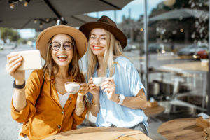 Beispielbild für das Formulieren von ALT-Texten mit zwei Frauen, die Kaffee trinken und ein Selfie machen.